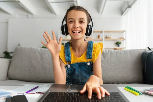 Chica en los auriculares con el ordenador portátil, saludando de la mano a la webcam —  Fotos de Stock