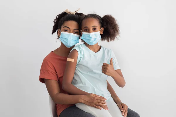 Chica negra mostrando el pulgar hacia arriba después de la inmunización —  Fotos de Stock