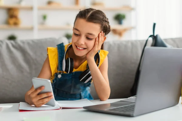 Menina sentada na mesa, conversando no telefone celular — Fotografia de Stock