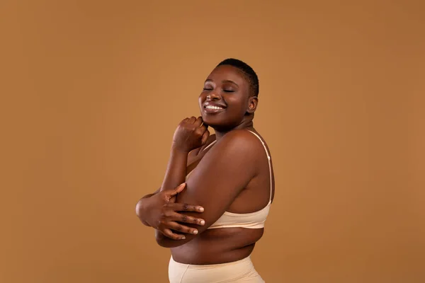 Portret van mooie plus size Afrikaanse Amerikaanse vrouw omarmen zichzelf — Stockfoto