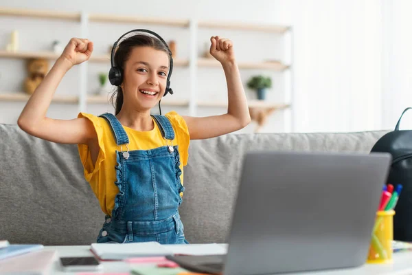 Retrato de menina da escola emocional balançando punhos usando laptop — Fotografia de Stock