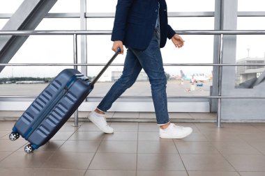 Hava Taşımacılığı Konsepti. Havaalanı binasında bavulla dolaşan tanınmayan bir adam.