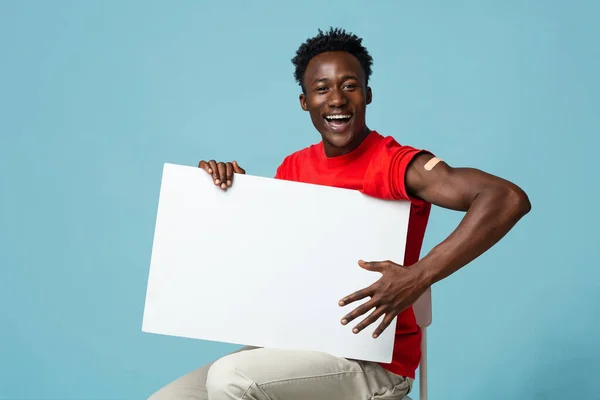 Alegre vacunado negro chico con yeso en brazo celebración en blanco placa —  Fotos de Stock