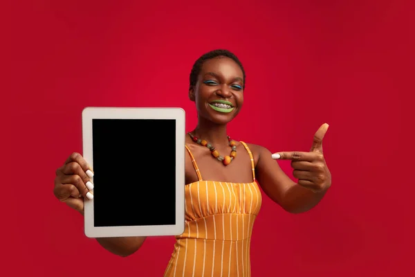 Cheerful black lady fashionista showing digital tablet with empty screen — Stock Photo, Image