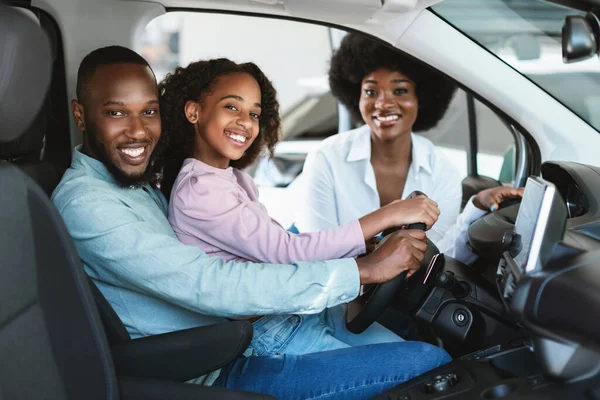 Família preta feliz comprando carro novo, carro de condução de teste, sorrindo para a câmera na concessionária de automóveis — Fotografia de Stock