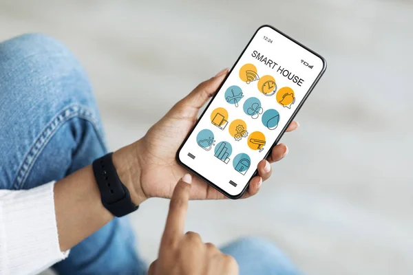 Κινητό τηλέφωνο με εφαρμογή smart home σε χέρια μαύρης κυρίας, κοντινό πλάνο — Φωτογραφία Αρχείου