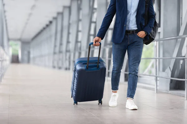 Hombre irreconocible con ropa casual caminando con equipaje en la terminal del aeropuerto — Foto de Stock