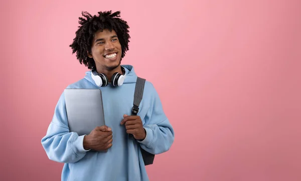 Estudiante adolescente afroamericano positivo con mochila, tableta PC y auriculares que estudian en línea sobre fondo rosa — Foto de Stock