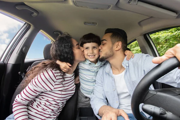 車の中で一緒に座っている間、彼らの小さな息子とキスを愛するアラビア人の両親 — ストック写真