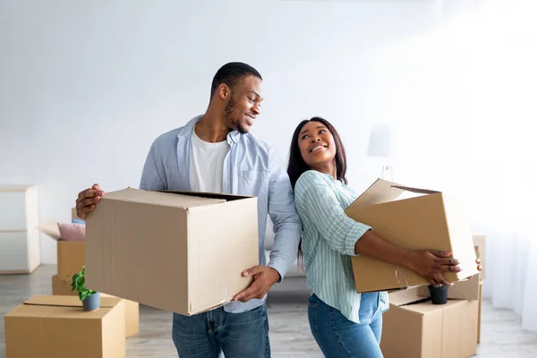 Concepto de reubicación del hogar. Amante pareja afroamericana llevando cajas de cartón en su nueva casa, espacio para copiar — Foto de Stock