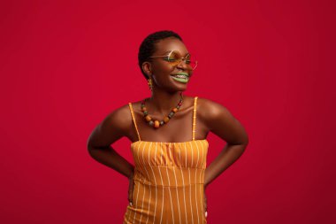 Güzel yaz kıyafetleri ve şık güneş gözlüğü takan neşeli siyah kadın.