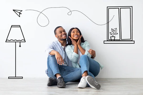 Amare coppia afro-americana immaginando interno del loro appartamento, seduto al piano vicino al muro con disegni doodle — Foto Stock