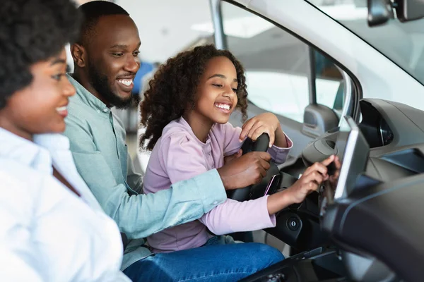 Alegre negro familia chequear salón de coches antes de comprar un automóvil nuevo, sentado dentro de auto, ir en la prueba de conducción — Foto de Stock