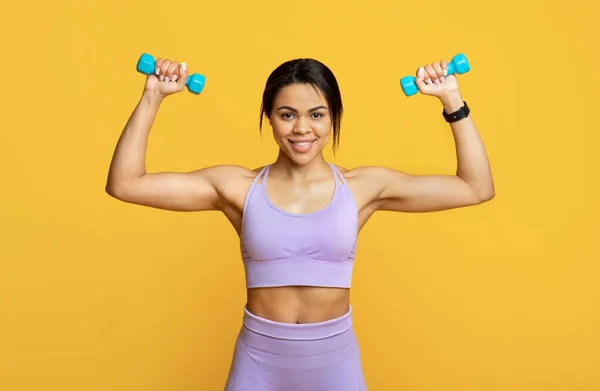 Determined Woman Doing Workout With Dumbbells Standing On Yellow Background  Stock Photo by ©Milkos 321667748