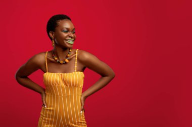 Çekici siyahi kadın gülüyor ve boş alana bakıyor.