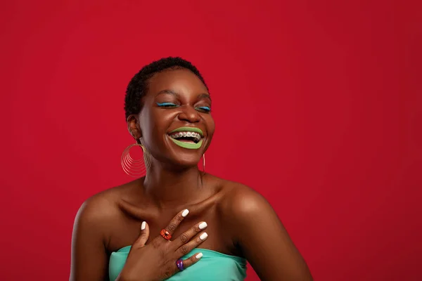 Sexy mujer afroamericana riendo en fondo de estudio rojo — Foto de Stock