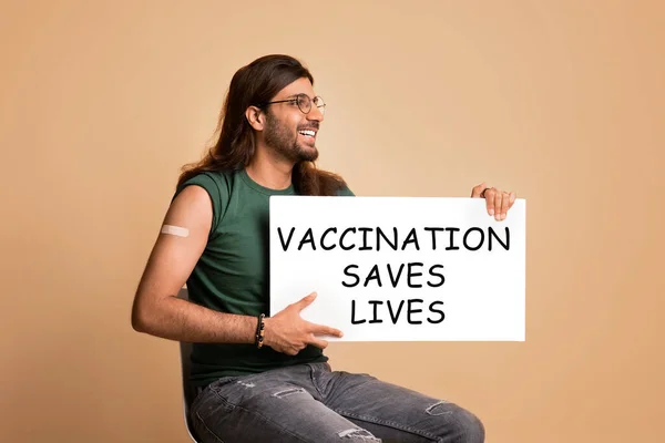 Positive middle-eastern vaccinated man with Vaccination Saves Lives board — Stock Photo, Image