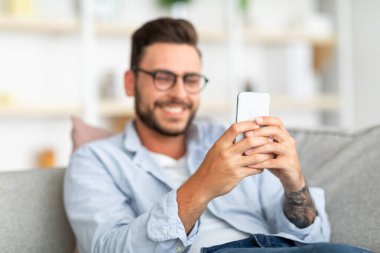 Mutlu milenyum çocuğu sevgilisiyle görüntülü sohbetten zevk alıyor, akıllı telefon ekranına bakıyor ve gülümsüyor, boş alan