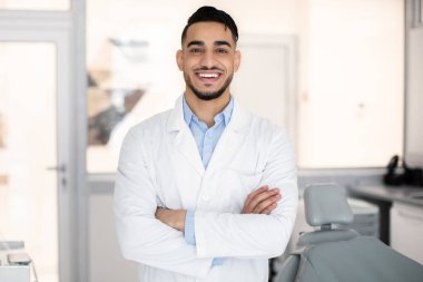 Stomatolojik Hizmetler. Gülümseyen Arap Dişçi Doktor Portresi
