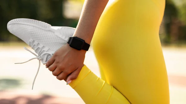 Deportiva mujer negra en amarillo ropa deportiva estiramiento pierna — Foto de Stock