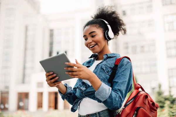 Emocionado estudiante afroamericano chica usando tableta digital al aire libre —  Fotos de Stock