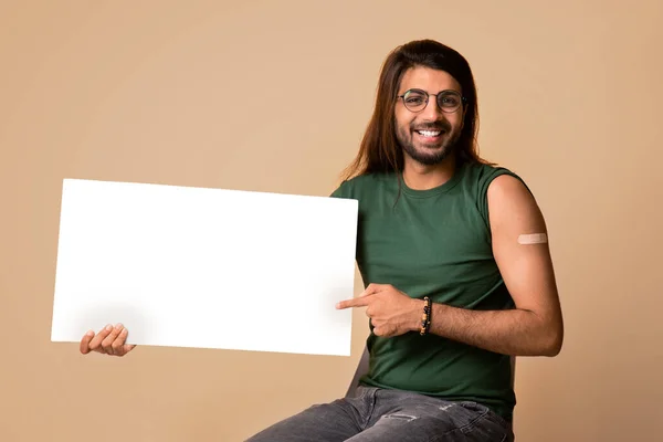 Belo árabe cara com gesso no ombro mostrando cartaz em branco — Fotografia de Stock