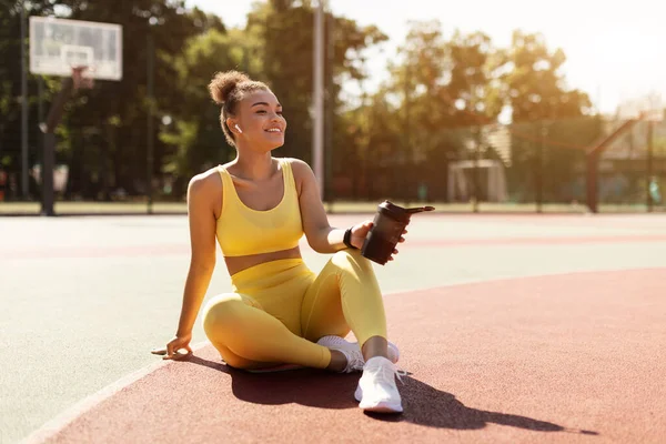 Deportiva mujer negra en ropa deportiva amarilla sosteniendo agitador — Foto de Stock