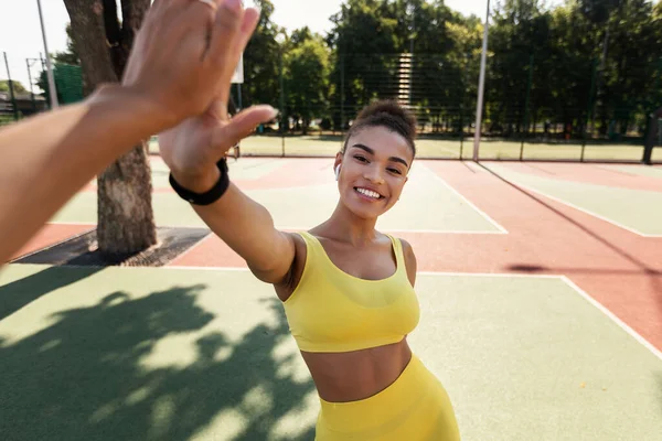 Deportiva mujer negra en ropa deportiva amarilla dando alta cinco — Foto de Stock