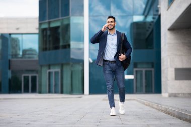 Genç ortadoğulu girişimci evine gidiyor, telefonla konuşuyor.