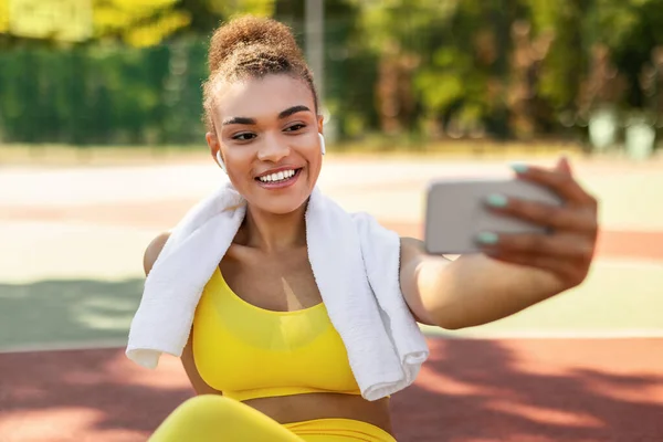 Senhora preta fazendo foto selfie no smartphone durante a pausa de treino — Fotografia de Stock