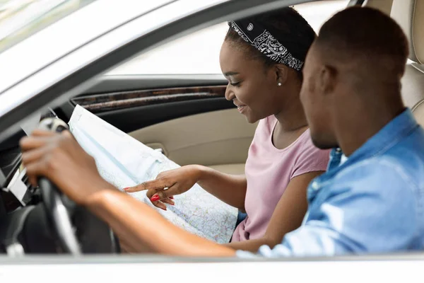 Feliz pareja negra viajeros mirando el mapa mientras conduce —  Fotos de Stock