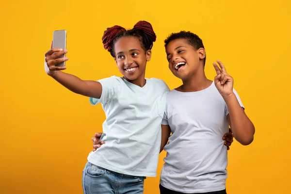 Schattig zwart broers en zussen het nemen van selfie samen op mobiele telefoon — Stockfoto