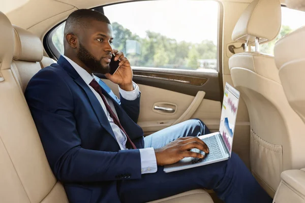 Reicher afroamerikanischer Geschäftsmann arbeitet im Auto — Stockfoto