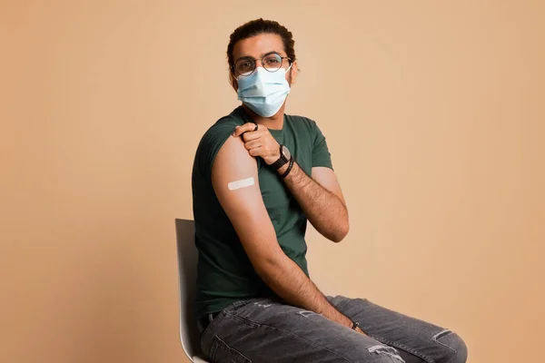 Arab man in face mask got vaccinated, showing shoulder — Stock Photo, Image