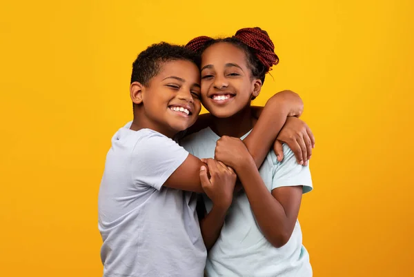 Liefdevolle zwart jongen knuffelen zijn mooi zus — Stockfoto