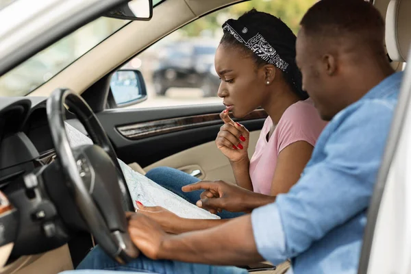 Pareja afroamericana viajando en coche, se perdió, chequeando mapa —  Fotos de Stock