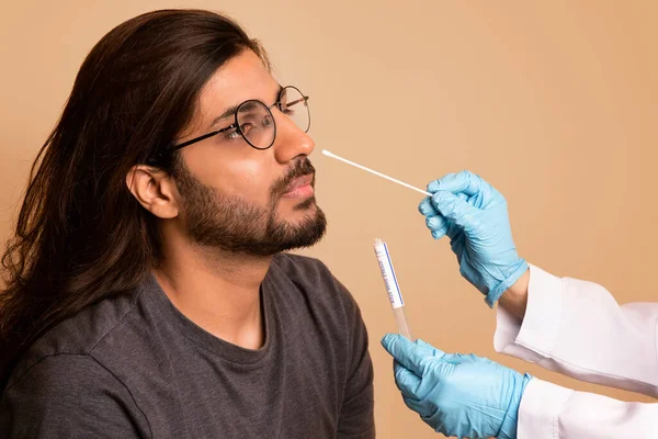 Sjuksköterska som tar nasal svabb för coronavirus prov från arabiska killen — Stockfoto