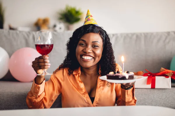 Neşeli Afrikalı Amerikalı kadın doğum günü pastası tutuyor. Kapalı alanda bayramı kutluyorlar. — Stok fotoğraf