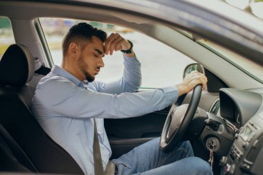 Üzgün Arap işadamı kafasına dokunuyor, trafiğe takılmış.