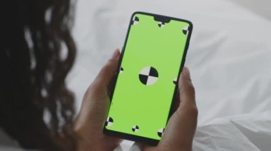 Yeşil renkli anahtar ekranlı modern akıllı telefon tanınmayan Afrikalı Amerikalı bir kadının elinde. Model için boş alan.