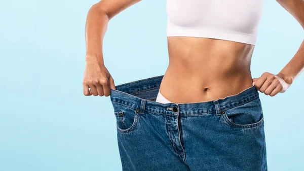 Närbild av smal passform kvinna dra stora lösa Jeans — Stockfoto