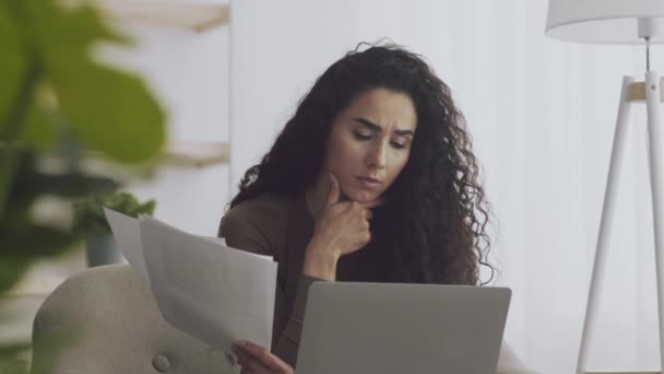 Giovane donna libera professionista pensierosa che lavora in remoto a casa, leggendo documenti e pensando a una nuova strategia di marketing — Video Stock