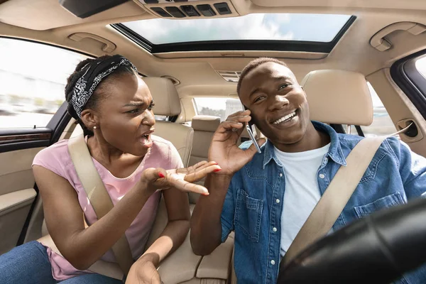 Negro mujer gritando a novio teniendo teléfono llamada mientras conducir —  Fotos de Stock