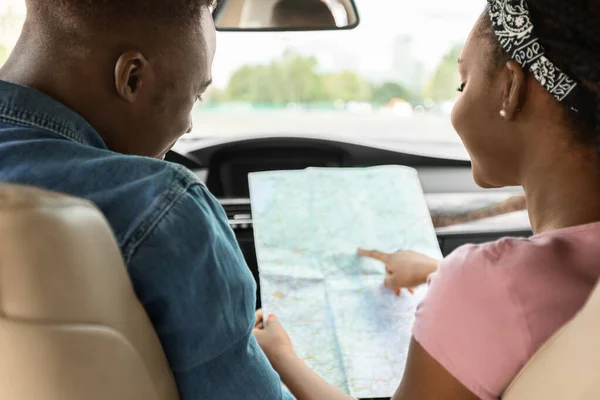 Señora negra ayudando a su novio conductor, chequeando mapa, vista trasera —  Fotos de Stock