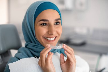 Ortodonti Konsepti. Başörtüsü İçinde Gülümseyen Müslüman Kadın Görünmez Parmaklıklar Tutuyor