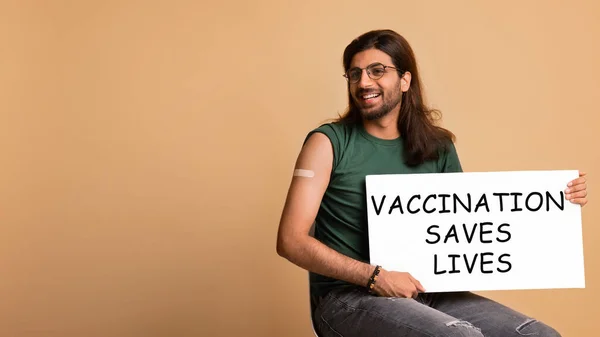 Homem árabe vacinado feliz com vacinação salva vidas placard — Fotografia de Stock