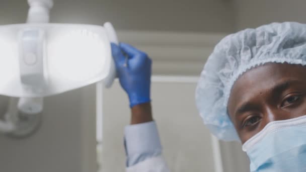 Cura dentária. Pontos de vista do paciente afro-americano dentista masculino fixando luzes e iniciar o tratamento na boca, usando ferramentas odontológicas — Vídeo de Stock