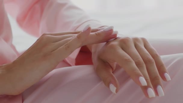 Concetto di auto-cura. Irriconoscibile giovane donna che applica crema idratante sulle mani a casa — Video Stock