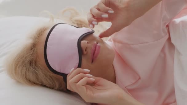 Bella donna che indossa la maschera del sonno svegliarsi a letto la mattina — Video Stock