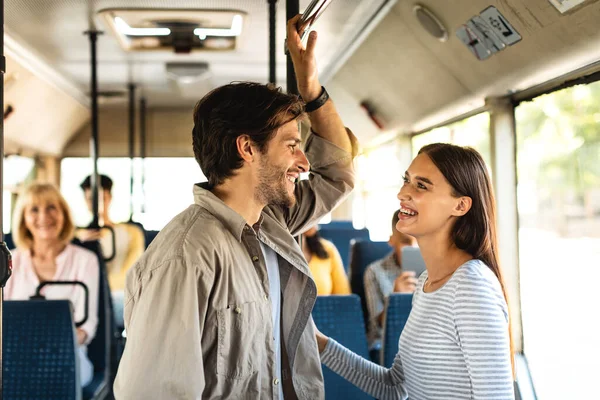 Beau couple souriant debout dans le bus et parlant — Photo